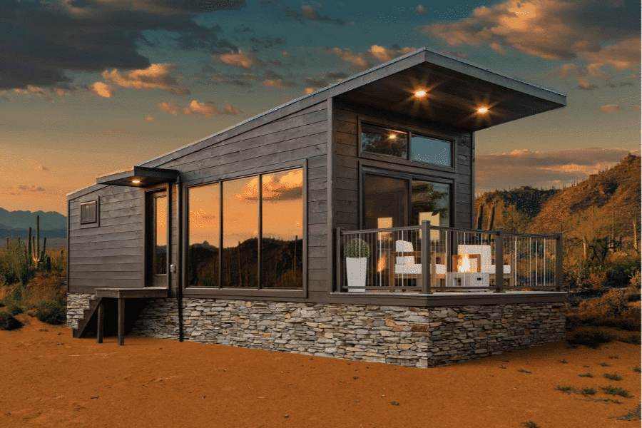 Rockwood modern park model tiny home with stone foundation and sunset backdrop.