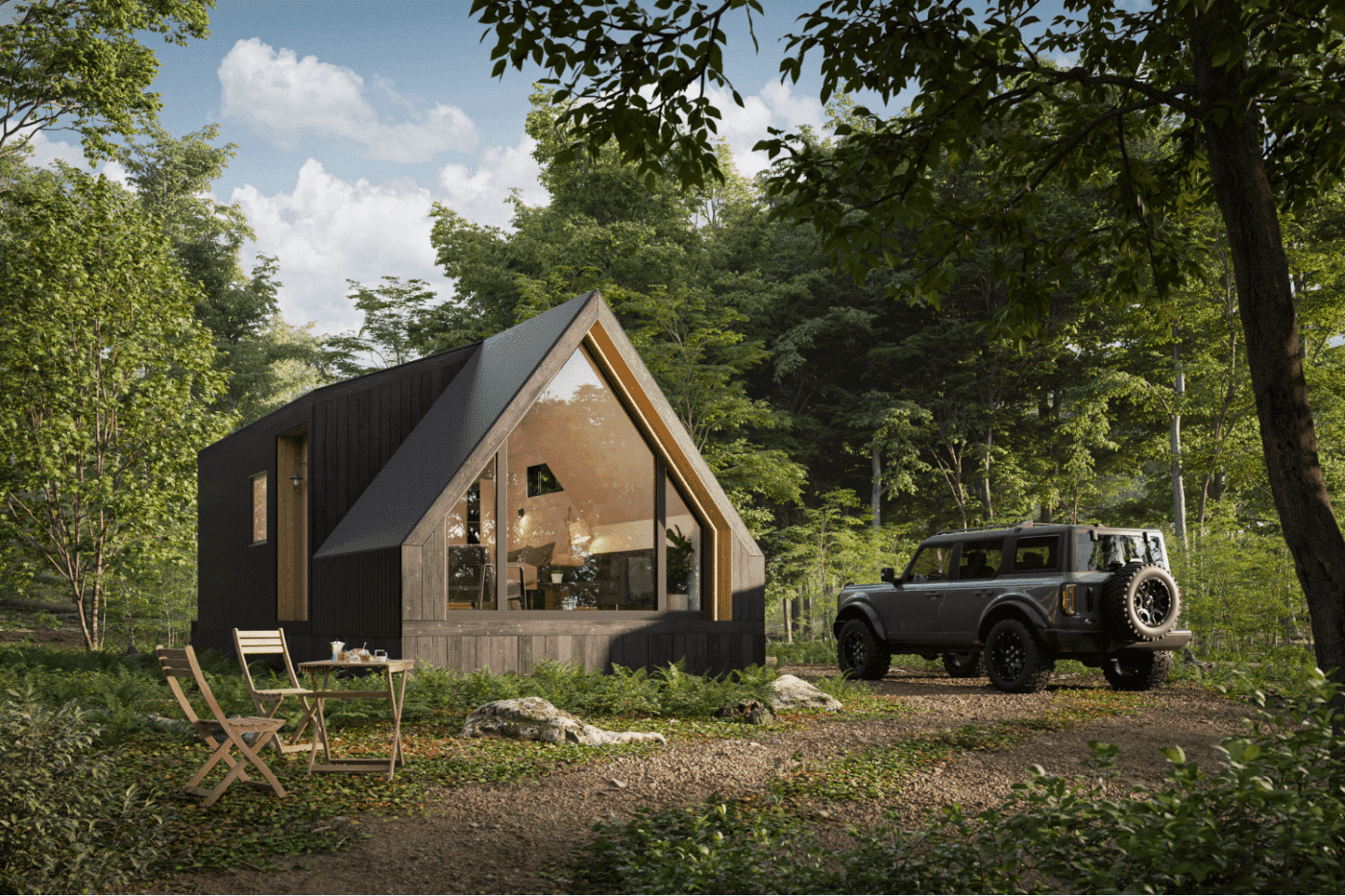 A-frame park model home in the woods with a modern black exterior and large front windows.