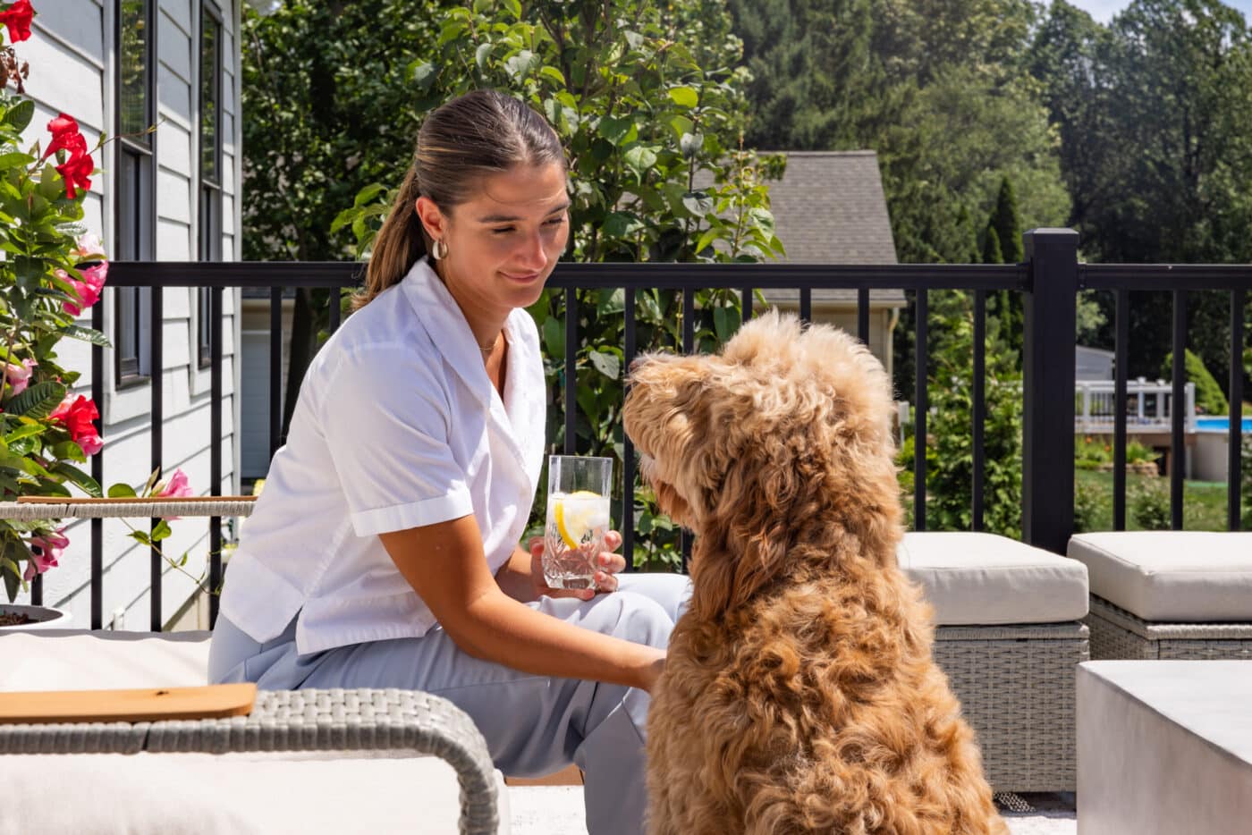 Lanie sitting with her dog on the back porch of her modern farmhouse