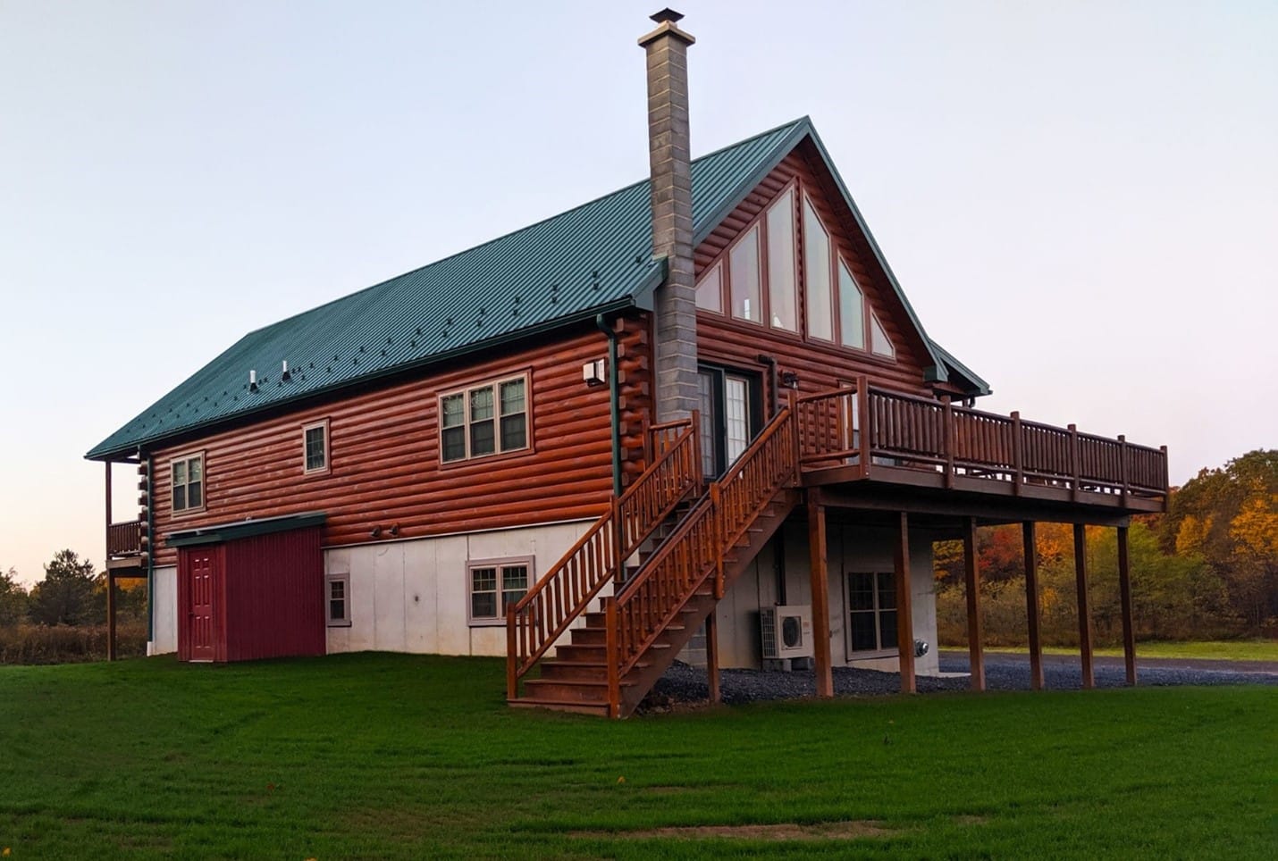 Chalet-style log cabin with large windows and a wraparound deck in Kentucky.