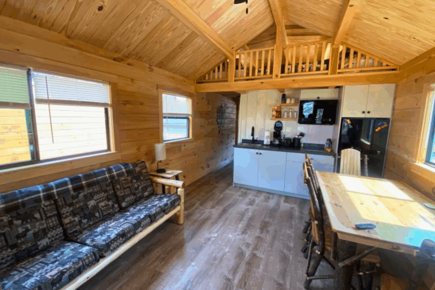 living room and lofted area of Aspen 1 park model log tiny home in houghton michigan