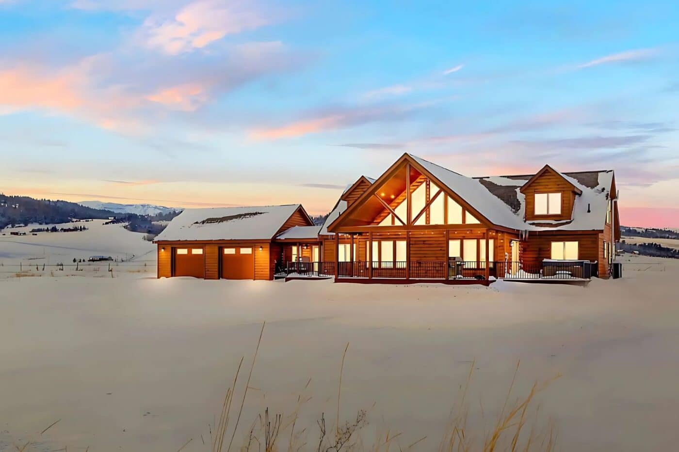 Log Cabin in the snow at sunset with lights in window