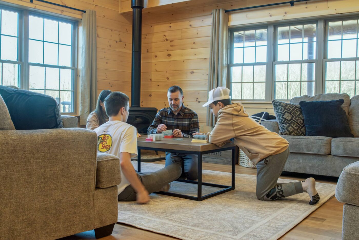 Family playing game inside living room of log cabin home