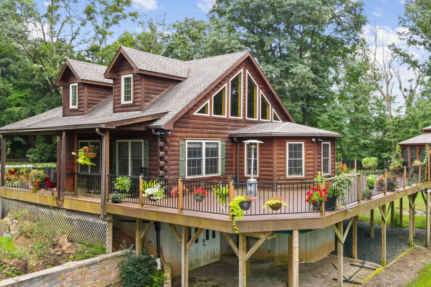FUll view of log cabin on extensive deck and basement/garage