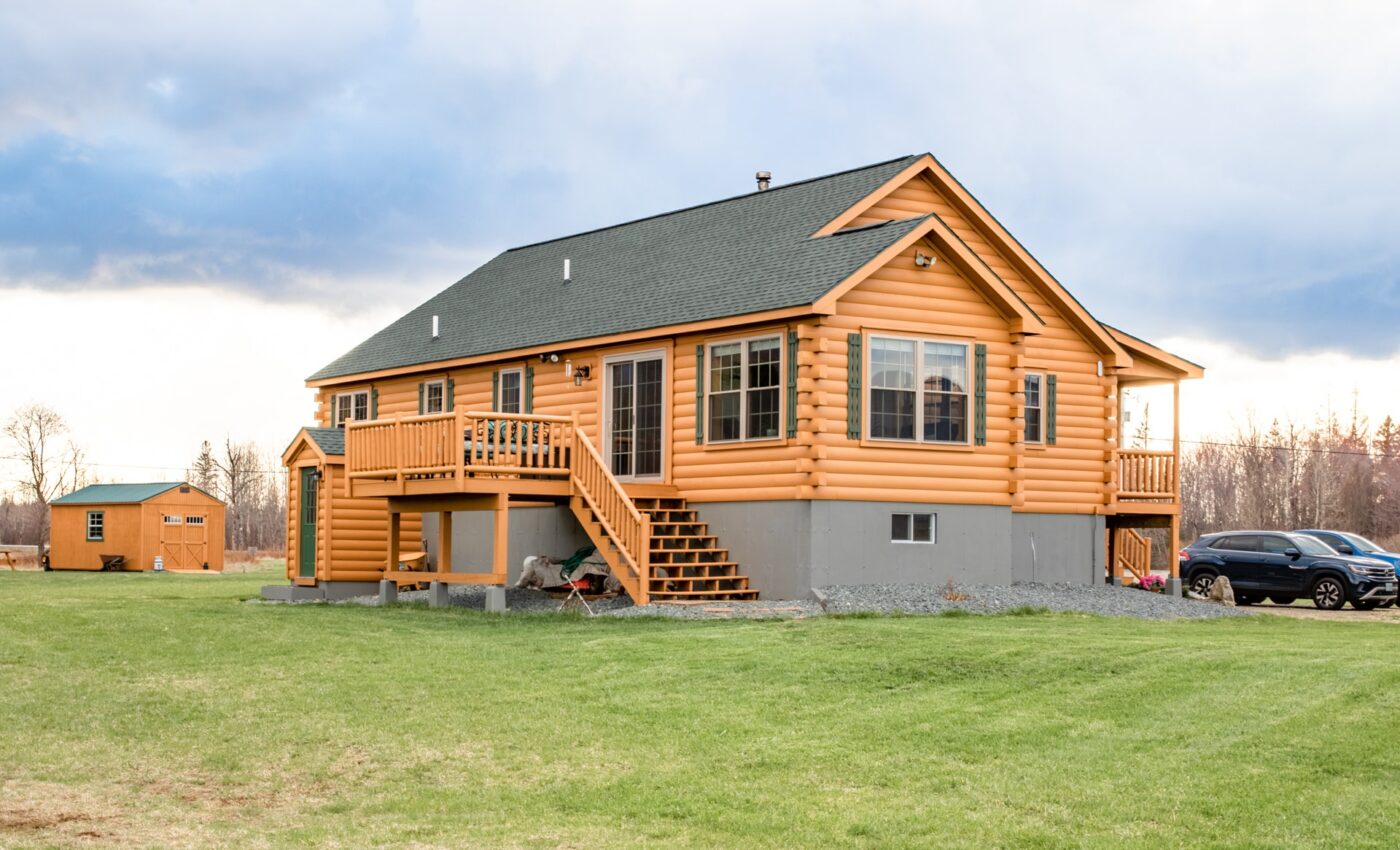 Musketeer log cabin in Pennsylvania with raised foundation and green shutters.