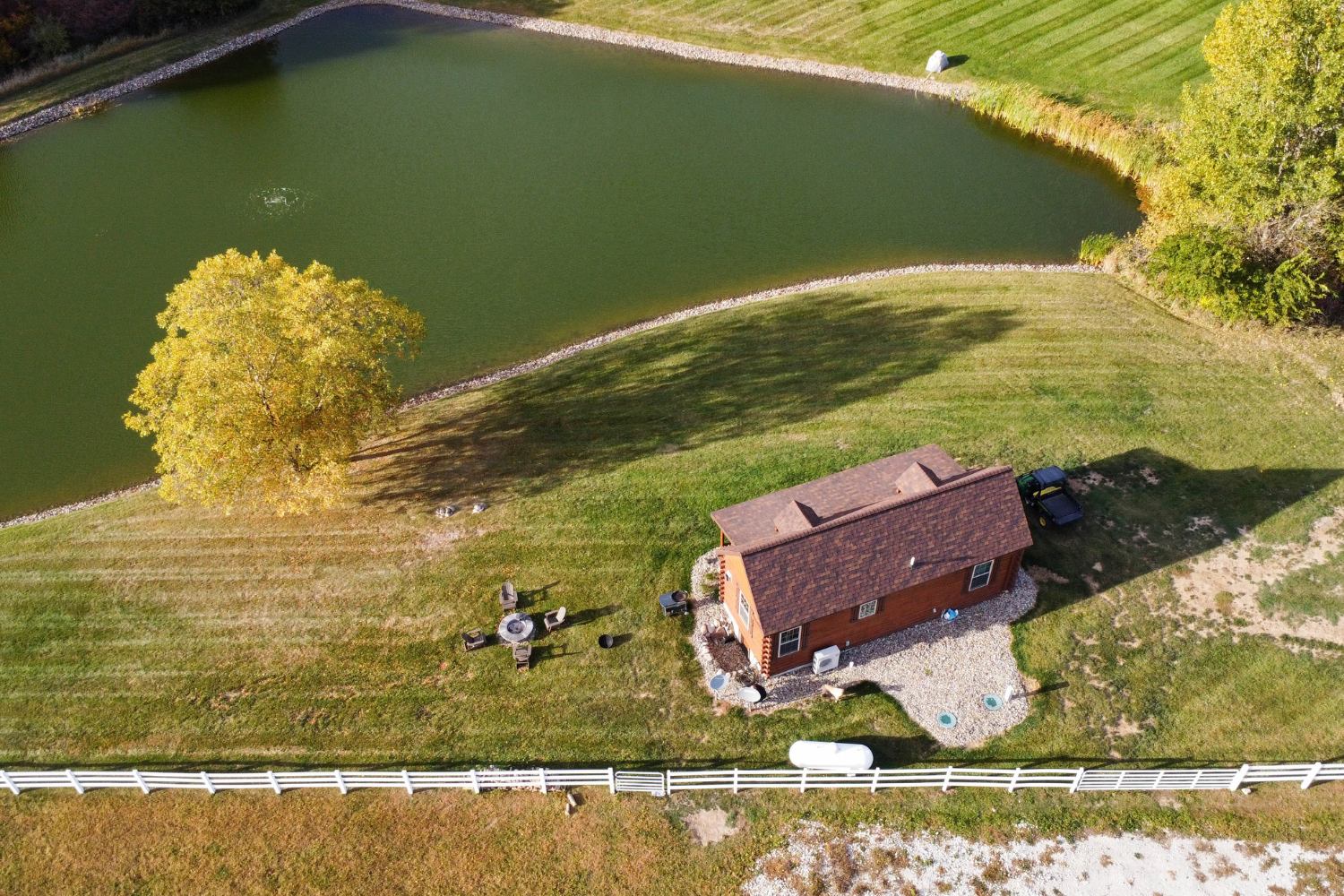 Overview of log cabin on land next to lake