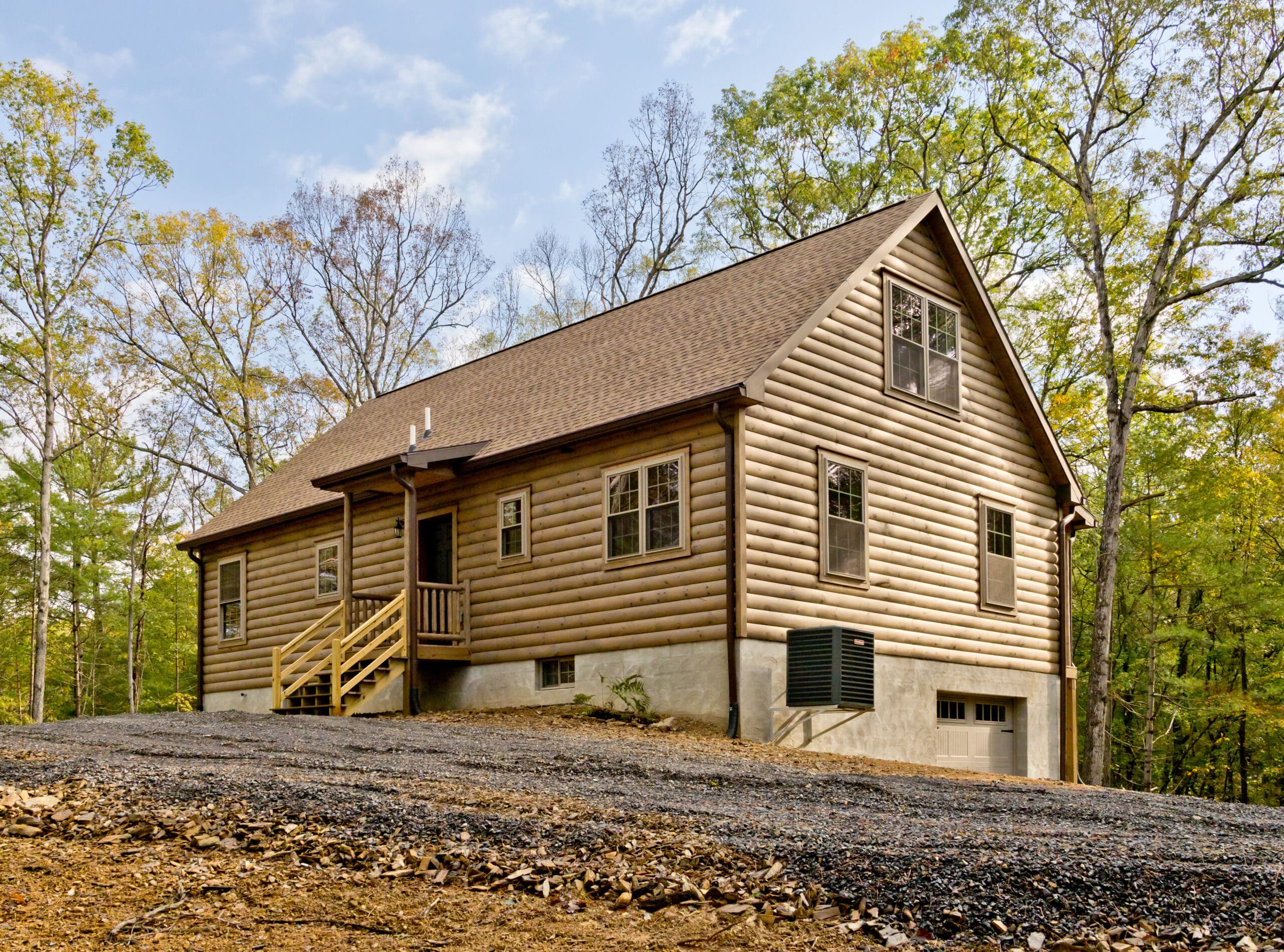 Mountaineer log cabin with wraparound deck set on a hillside in Tennessee.
