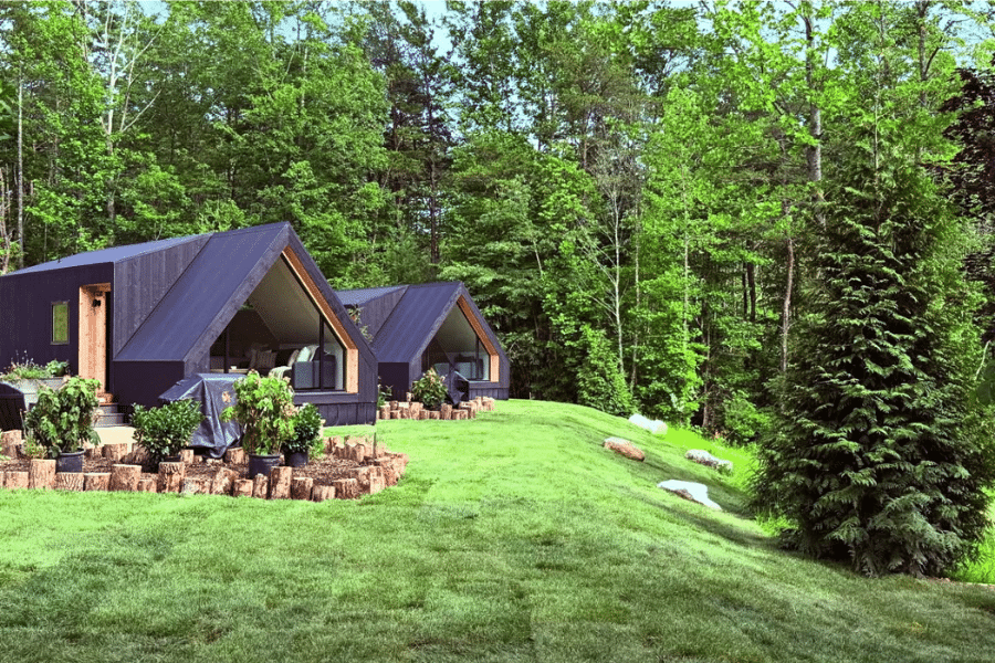 2 black A frame ADUs on a hill