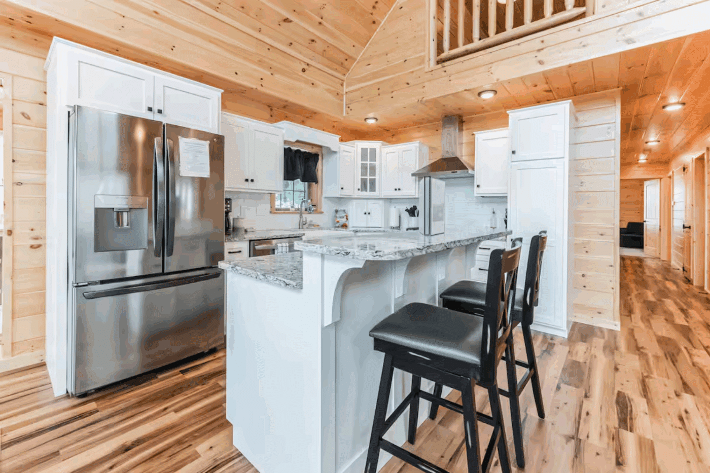 white cabinets and breakfast bar island in Mountaineer Deluxe located in Sarnac Lake New York