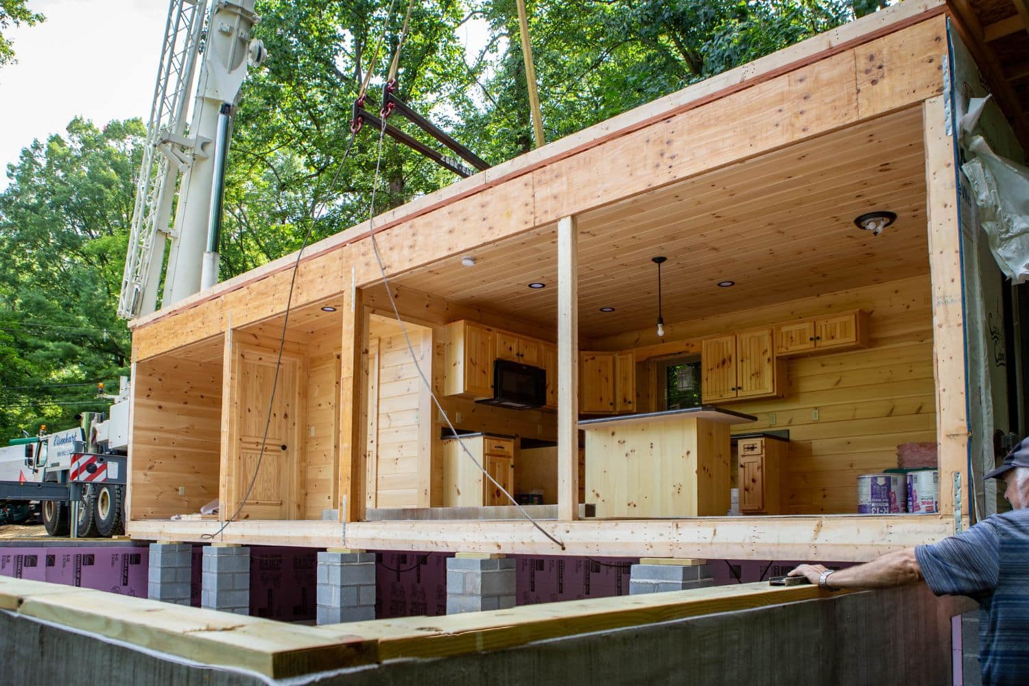 Log cabin being placed on foundation during log cabin construction