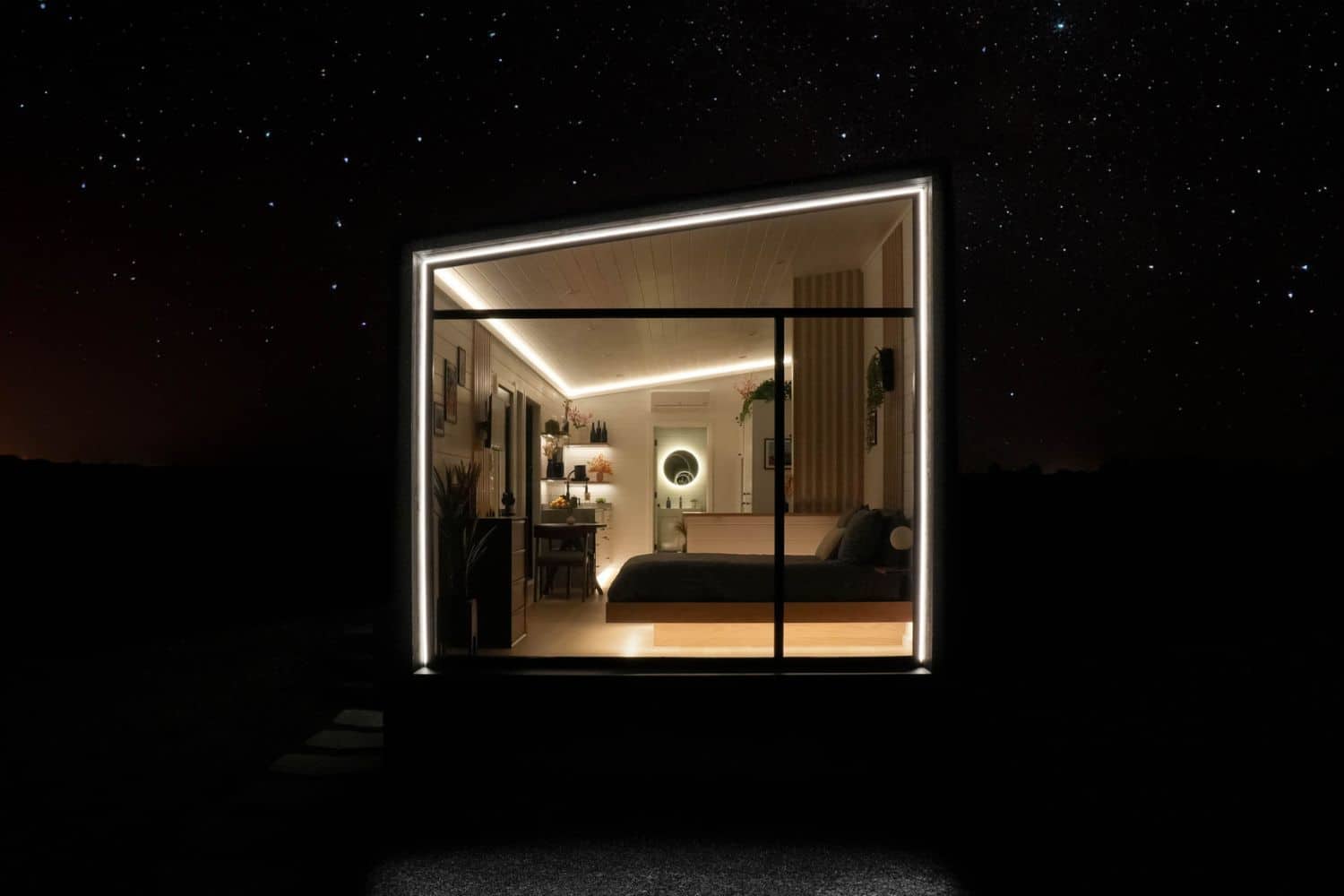 Tiny home window at night with view of bedroom and living area