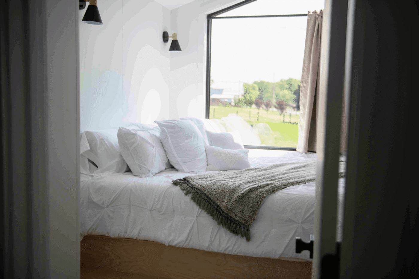 Bedroom with King sized bed in a frame tiny home built and designed by Psy Homes in New Holland Pa